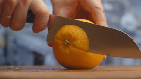 Close-up-of-cut-orange-on-a-board-in-the-kitchen-on-a-wooden-board